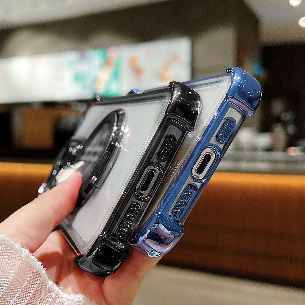 Hand holding two phone cases, one blue and one clear, with a blurred indoor background.